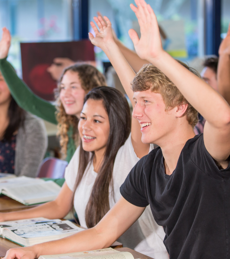 Bruce College students in class raising their hands